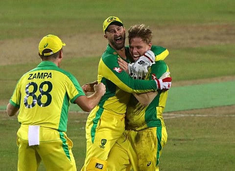 Australia's Nathan Ellis celebrates with his teammates after taking the wicket of Bangladesh's Mahedi Hasan to complete his hat-trick.