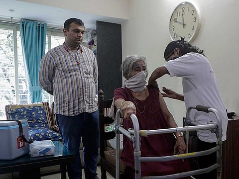 A health worker administers COVID-19 vaccine to an elderly woman during a door to door vaccination programme in Mumbai, on August 5, 2021.