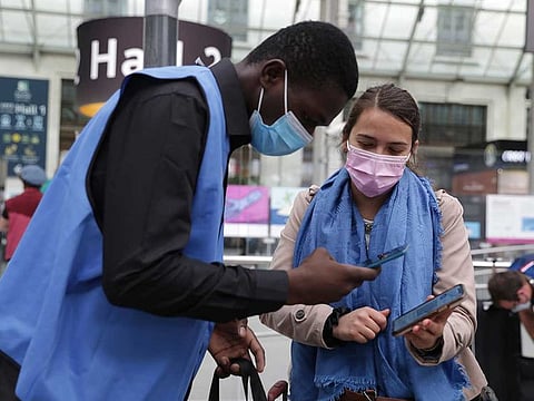 A railway employee checks the COVID-19 health pass that everyone in the country needs to enter cafes, trains and other venues, Monday Aug.9, 2021 at the Gare de Lyon train station in Paris.