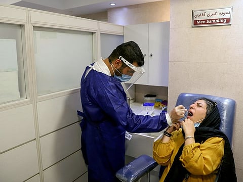 A medic takes a PCR test as coronavirus disease cases spike, in Tehran.