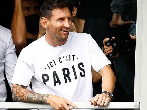 Argentinian football player Lionel Messi salutes supporters from a window after he landed at Le Bourget airport ahead of signing for PSG