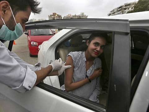 A woman receives the Sinovac COVID-19 vaccine from a health worker at a drive-through vaccination center, in Karachi. Chinese Ambassador said that China would provide 6 million vaccine doses to Pakistan this week while 100 million vaccine doses would be provided by the end of the year.