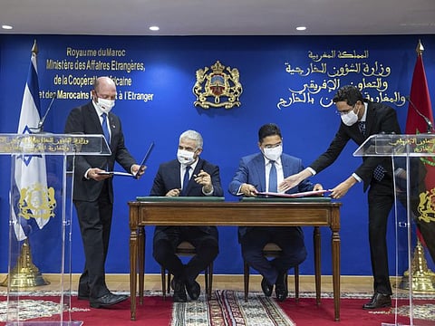 Moroccan Foreign Minister Nasser Bourita, centre right, and Israeli Foreign Minister Yair Lapid, sign cooperation agreements between the two countries, in Rabat, on August 11, 2021.