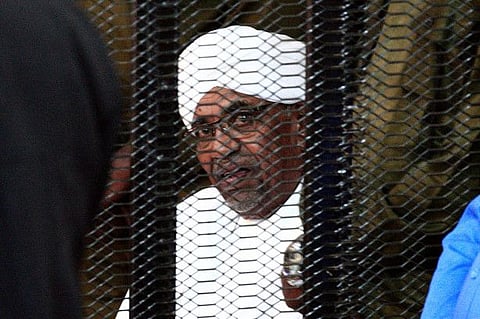 udan's deposed military ruler Omar Al Bashir looks on from a defendant's cage during the opening of his corruption trial in Khartoum in a file photo..