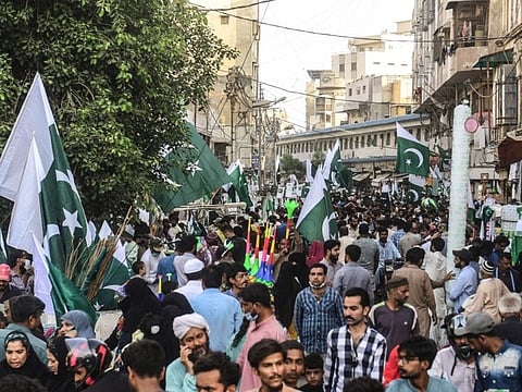 Pakistanis buy national flags and other items at a market in Karachi on the eve of the country's 75th Independence Day, which marks the end of British colonial rule.