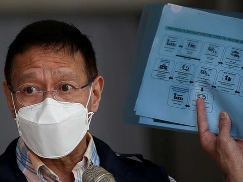 Philippine Health Secretary Francisco Duque holds a flowchart for the COVID-19 vaccine simulation during a press briefing at the Research Institute for Tropical Medicine in Muntinlupa, Metro Manila, Philippines, February 9, 2021.