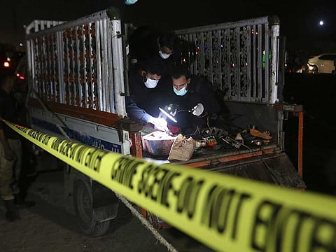Pakistani investigators examine a truck at the site of an explosion, in Karachi, Pakistan, Saturday, Aug. 14, 2021.