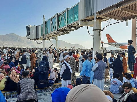 Afghans crowd at the tarmac of the Kabul airport on August 16, 2021, to flee the country as the Taliban were in control of Afghanistan after President Ashraf Ghani fled the country and conceded the insurgents had won the 20-year war.