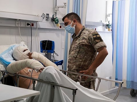 A soldier speaks to one of the injured in the fuel tank explosion in Akkar.