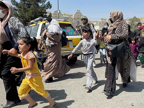 Women with their children try to get inside Hamid Karzai International Airport in Kabul, Afghanistan August 16, 2021.
