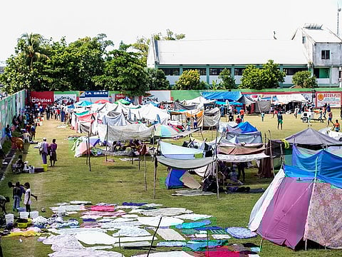 People circulate at an encampment set up on a football field after Saturday's 7.2 magnitude quake, in Les Cayes, Haiti August 16, 2021.