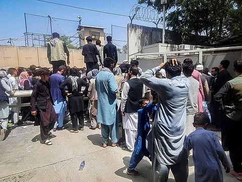 Afghan people gather outside the French embassy in Kabul on August 17, 2021 waiting to leave Afghanistan.