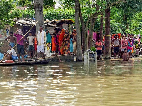 Villagers wait for relief at a flood hit area of Raghopur in Hajipur, Tuesday, Aug. 17, 2021.