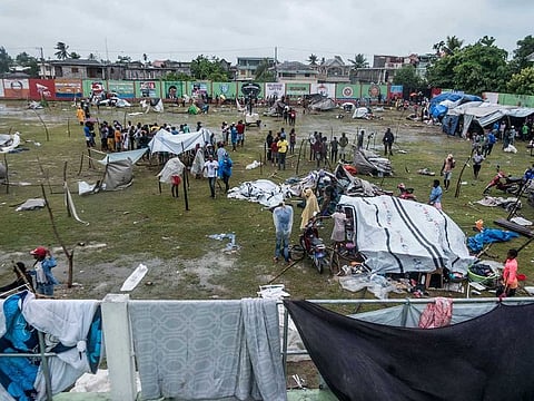 People make repairs and create shelter, after spending the night outside in the aftermath of the earthquake, facing the severe inclement weather of Tropical Storm Grace near Les Cayes, Haiti on August 17, 2021.