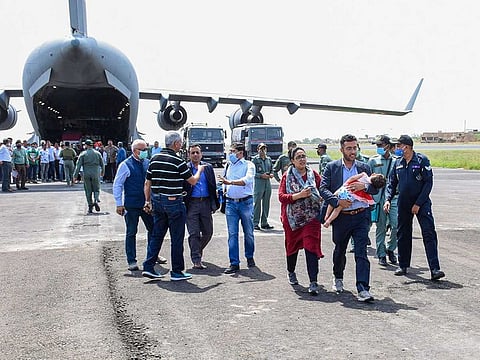 Government officials welcome Indian citizens on their arrival from crisis-hit Afghanistan by an Indian Air Force's C-17 aircraft, in Jamnagar, Tuesday, Aug. 17, 2021.