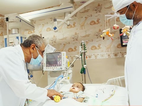 Dr Hussein Nasseer Matlik with baby Hamdan and the child's father Rashid Al Hassani at Burjeel Hospital - Abu Dhabi.