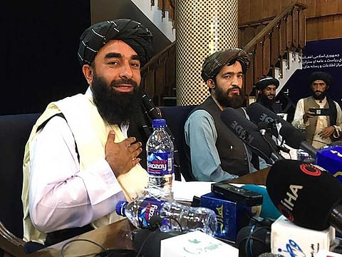 Taliban spokesperson Zabihullah Mujahid (L) attends the first press conference in Kabul on August 17, 2021, following their stunning takeover of Afghanistan.
