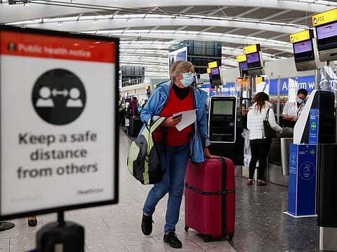 A passenger walks with her luggage at the Terminal 5 departures area at Heathrow Airport in London, Britain.