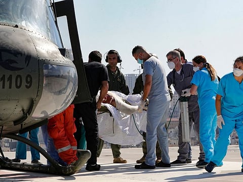 A man with severe burn injuries, sustained in an the fuel tank explosion in Lebanon's northern region of Akkar that killed 28 people and left nearly 80 wounded, is carried on a stretcher from a helicopter, after being transported for treatment at the severe burns unit of the Geitaoui hospital in the capital Beirut.