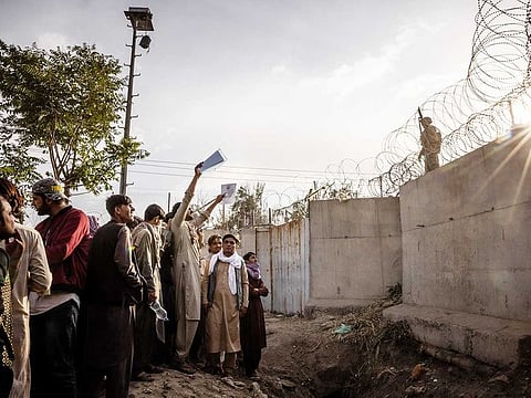 People wave at American soldiers at Hamid Karzai International Airport in Kabul, Afghanistan, Aug. 22, 2021.