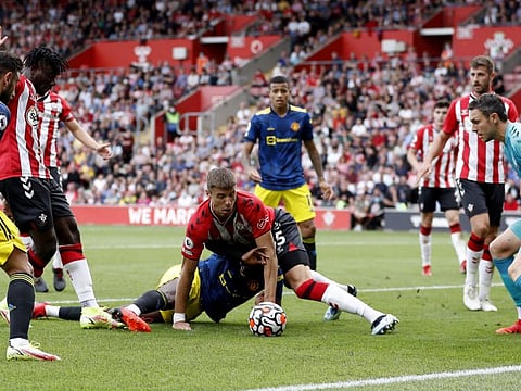 Manchester United's Paul Pogba in action with Southampton's Jan Bednarek as Alex McCarthy looks on at St Mary's stadium.