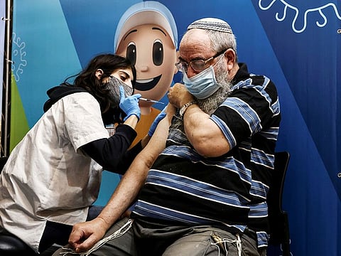 A man receives his third dose of the COVID-19 vaccine in Jerusalem.