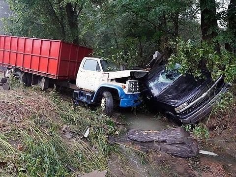 A truck and a car sit in a creek, after they were washed away the day before in McEwen, Tennessee.