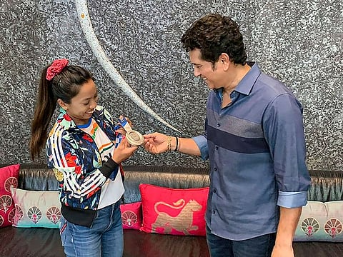 Tokyo Olympics silver medallist weightlifter Saikhom Mirabai Chanu shows her medal to cricket legend Sachin Tendulkar