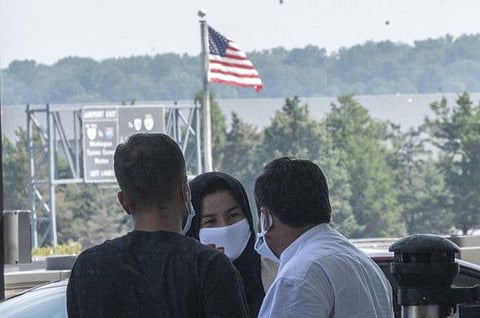 Refugees from Afghanistan wait to board a bus after arriving and being processed at Dulles International Airport in Dulles, Virginia, on August 23, 2021.