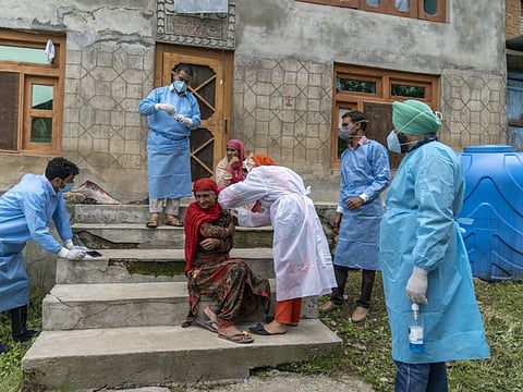 A member of a 'door-to-door' vaccination team inoculates a resident during a vaccination drive at a village in the Budgam district of Jammu and Kashmir.