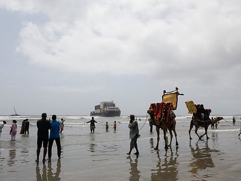 People look at the cargo ship Heng Tong 77 before it is dragged by a salvage crane, after it ran aground near Sea View beach in Karachi, on August 24, 2021. Pakistan on Wednesday reported 141 deaths from COVID-19, one of its highest tallies since May.