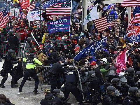 In this file photo taken on January 06, 2021 Trump supporters clash with police and security forces as they push barricades to storm the US Capitol in Washington DC.