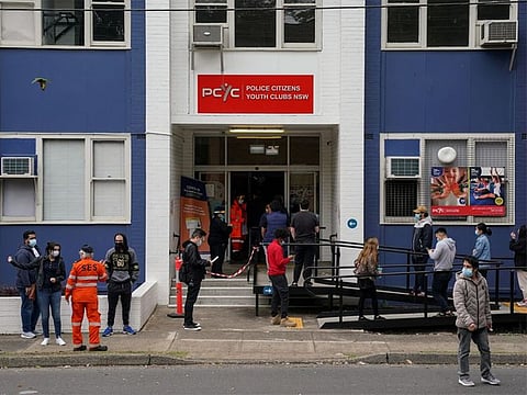 People wait in line outside a COVID-19 vaccination clinic in the Bankstown suburb during a lockdown to curb an outbreak of cases in Sydney.
