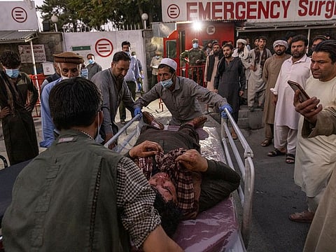 A person wounded in a bomb blast outside the Kabul airport in Afghanistan on Thursday, arrives at a hospital in Kabul.