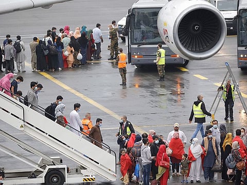 People disembark from a chartered Air Belgium Afghanistan evacuation flight at Melsbroek Military Airport, in Melsbroek, Belgium. The plane contained individuals who previously had helped the Belgian mission in Afghanistan. The plane landing in Melsbroek originated in Islamabad, Pakistan.