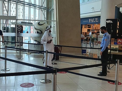 Visitors entering Al Wahda Mall in Abu Dhabi have to show the status on their Al Hosn app to mall security in order to be allowed inside..