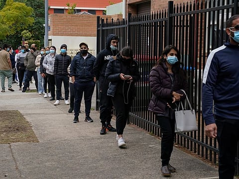 People wait in line outside a vaccination clinic in the Bankstown suburb in Sydney.