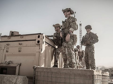 US service members assist at an Evacuation Control Check Point (ECC) during an evacuation at Hamid Karzai International Airport.
