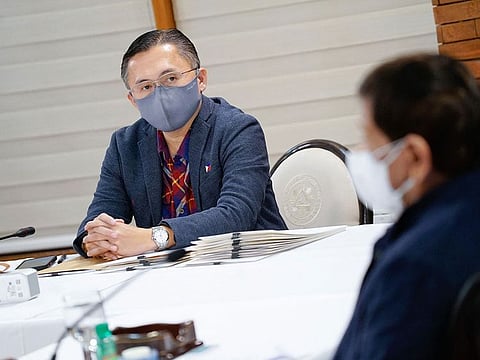 Senator Christopher Lawrence "Bong" Go (L) listens to Philippine President Rodrigo Duterte (R) during a meeting.