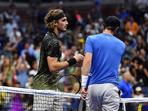 Greece's Stefanos Tsitsipas (L) shakes hands with Britain's Andy Murray after winning their 2021 US Open Tennis tournament men's singles first round match