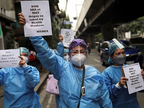 Healthcare workers hold a protest outside the Philippines' Department of Health, demanding better wages and benefits amid rising coronavirus disease infections, in Manila.