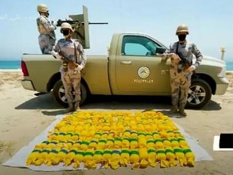 Saudi officers pose with some of the drugs haul.