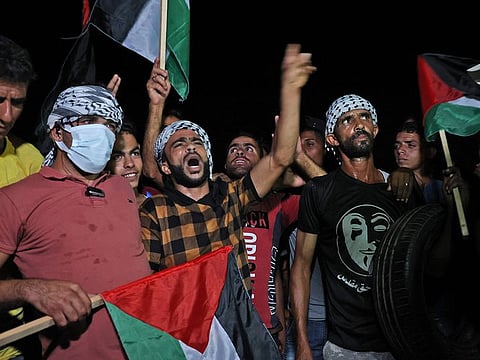 Palestinians gather on September 2, 2021 during a night protest along the border fence with Israel, east of Khan Yunis in the southern Gaza Strip.