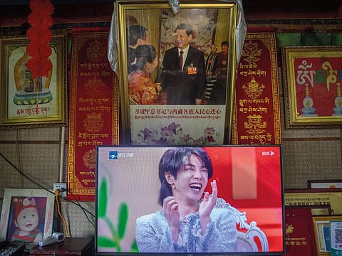 In this June 4, 2021, file photo, a television shows a broadcast of a Chinese talk show program as it sits beneath a photo of Chinese President Xi Jinping in a home converted into a tourist homestay in Zhaxigang village near Nyingchi in western China’s Tibet Autonomous Region.