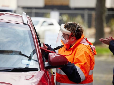 A health worker attends to a member of the public at a drive-thru Vaccination Centre set up at the Papakura Marea meeting ground in Auckland, on September 1, 2021.