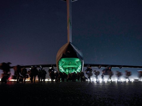 In this August 30, 2021, file photo provided by the US Air Force, soldiers, assigned to the 82nd Airborne Division, prepare to board a U.S. Air Force C-17 Globemaster III aircraft at Hamid Karzai International Airport in Kabul, Afghanistan.