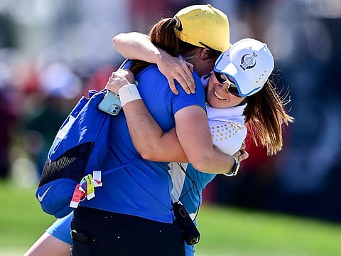 Europe's Leona Maguire celebrates with her sister Lisa after defeating United States' Jennifer Kupcho on the 15th hole during the singles matches at the Solheim Cup