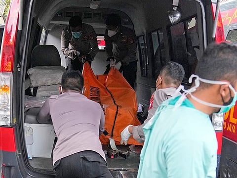 Officers load a body bag containing the body of a victim of a prison fire to be transferred to the national police hospital for identification at the local hospital's morgue in Tangerang on the outskirts of Jakarta on September 8, 2021.