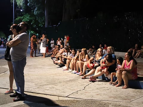 Locals sit on a sidewalk after a strong earthquake in Acapulco, Mexico, on Tuesday, September 7, 2021. The quake struck southern Mexico near the resort of Acapulco, causing buildings to rock and sway in Mexico City nearly 200 miles away.