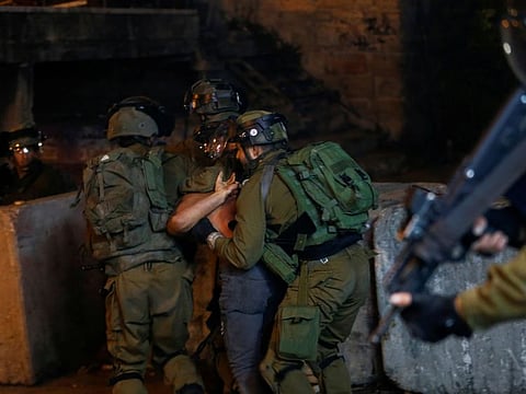 Israeli forces detain a man during a protest in solidarity with prisoners following the escape of six Palestinian militants from an Israeli prison, in Hebron, West Bank, on September 9, 2021.